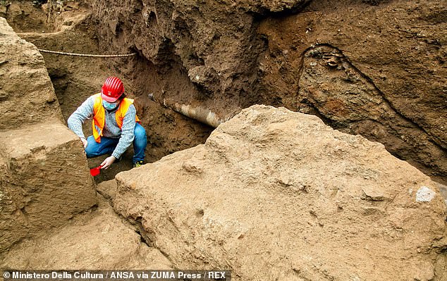 Adjacent to the tombs, the team's excavations also uncovered the remains of a young man who appeared to have been buried in the bare earth. Pictured: an archaeologist carefully excavates the some 2,000-year-old tombs in the Appio Latino quarter of Rome